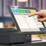 Doigt appuyant sur l'écran d'une caisse tactile