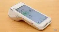 Terminal de Flatpay vue 3/4 gauche sur une table en bois